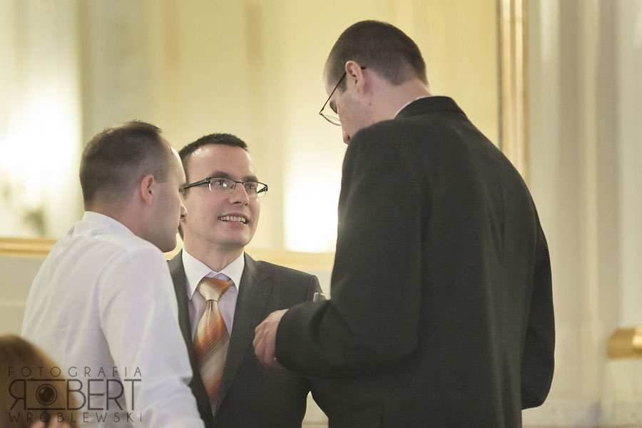 Pan Młody całuje Pannę Młodą w czoło, czuły moment.