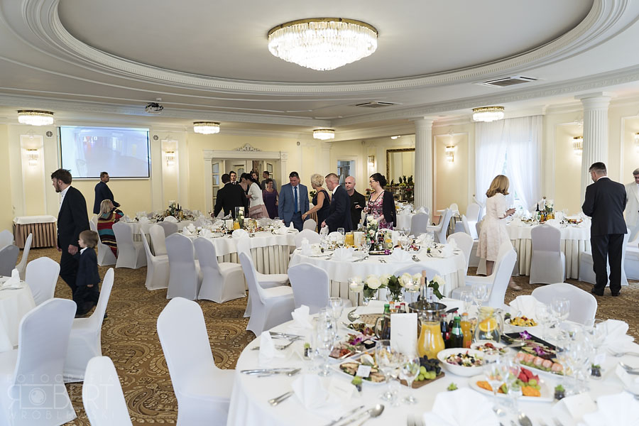 Goście weselni zajmują miejsca przy stołach w Pałacyku Otrębusy