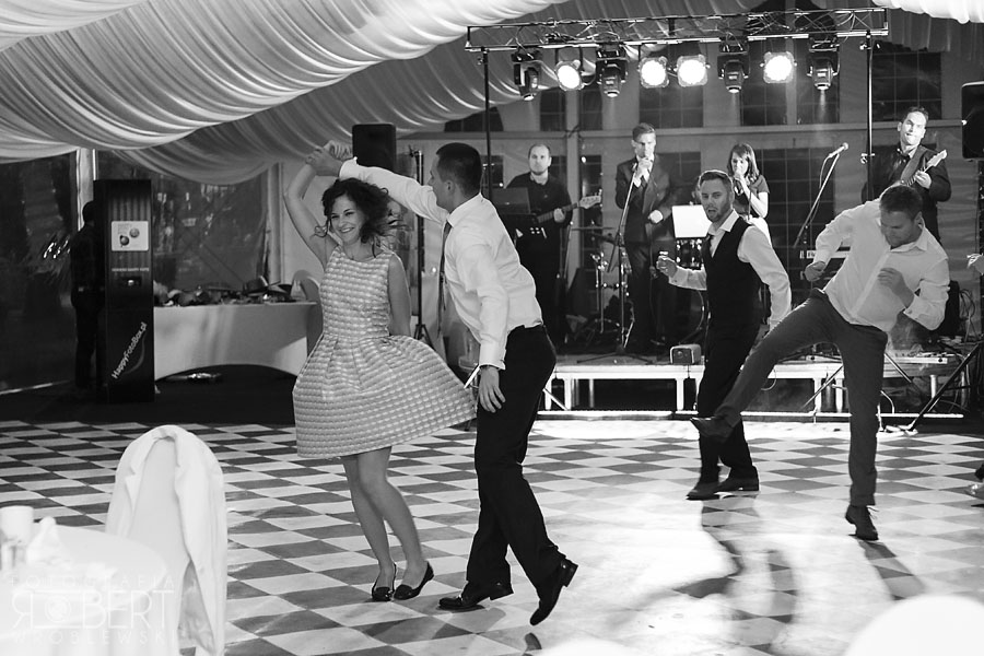 Nowożeńcy idą przez ogród w deszczu kwiatów